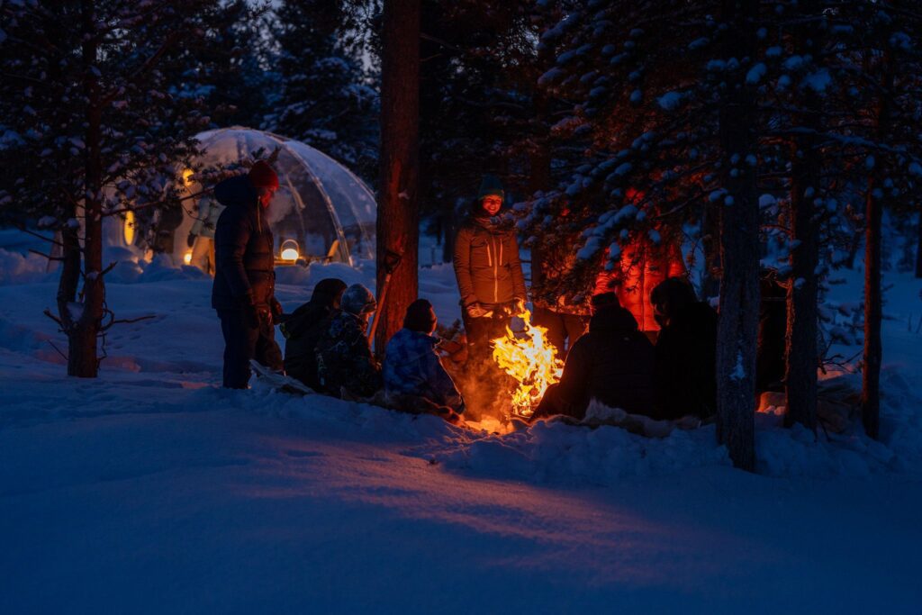 Family sitting around a bonfire close to Aurora Dome at ONGA Boutique Lodge